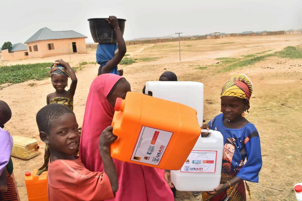 Children carrying water containers received through a WASH intervention