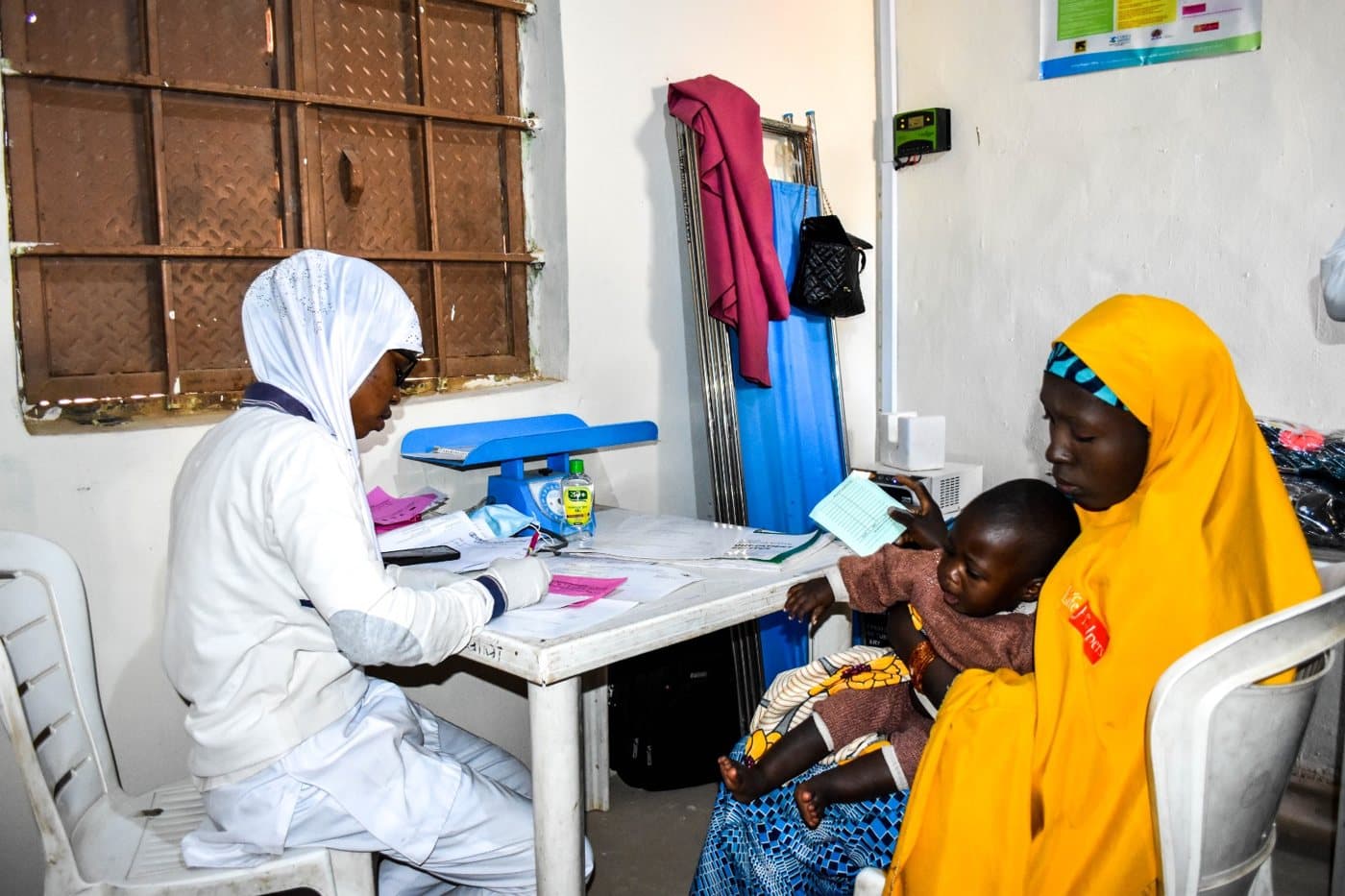 Health worker attending to a mother and her child at a health facility