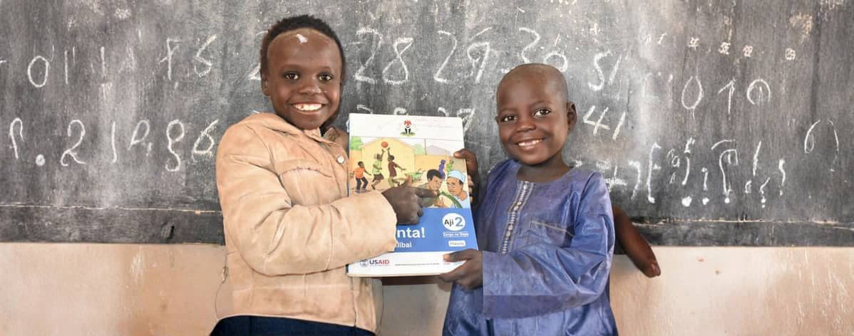 Pupils holding learning materials in a classroom